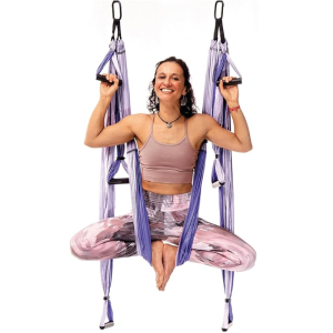 Columpio de yoga aéreo color púrpura instalado en espacio interior, disponible en Ambarayoga Quito